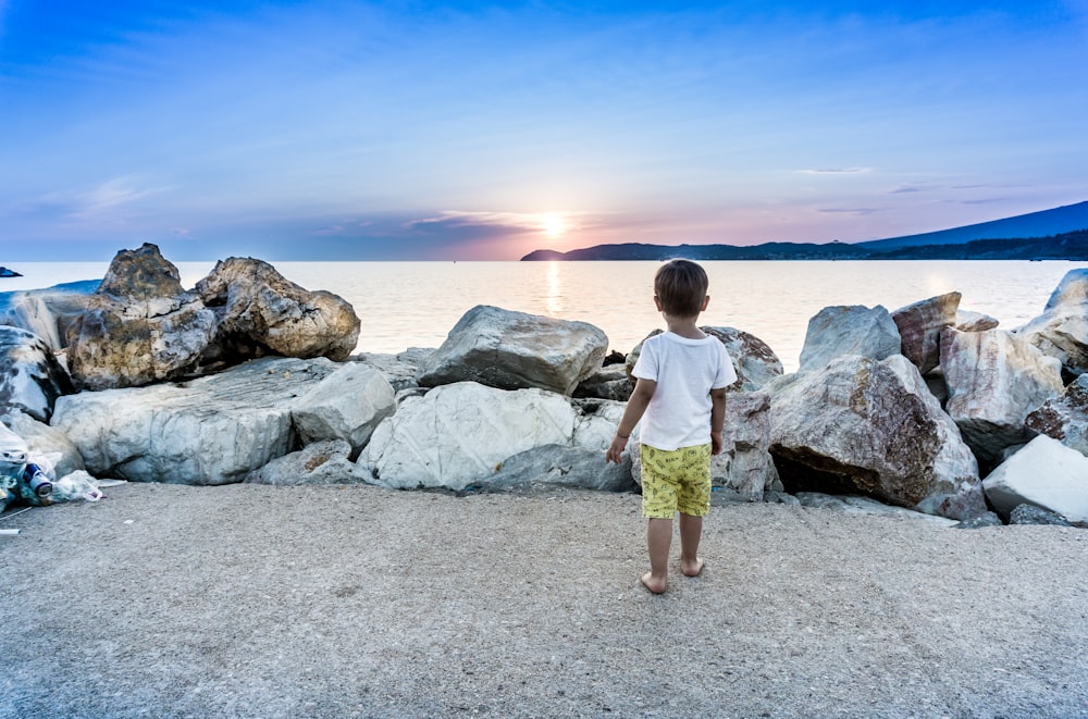 boy standing by a seawall