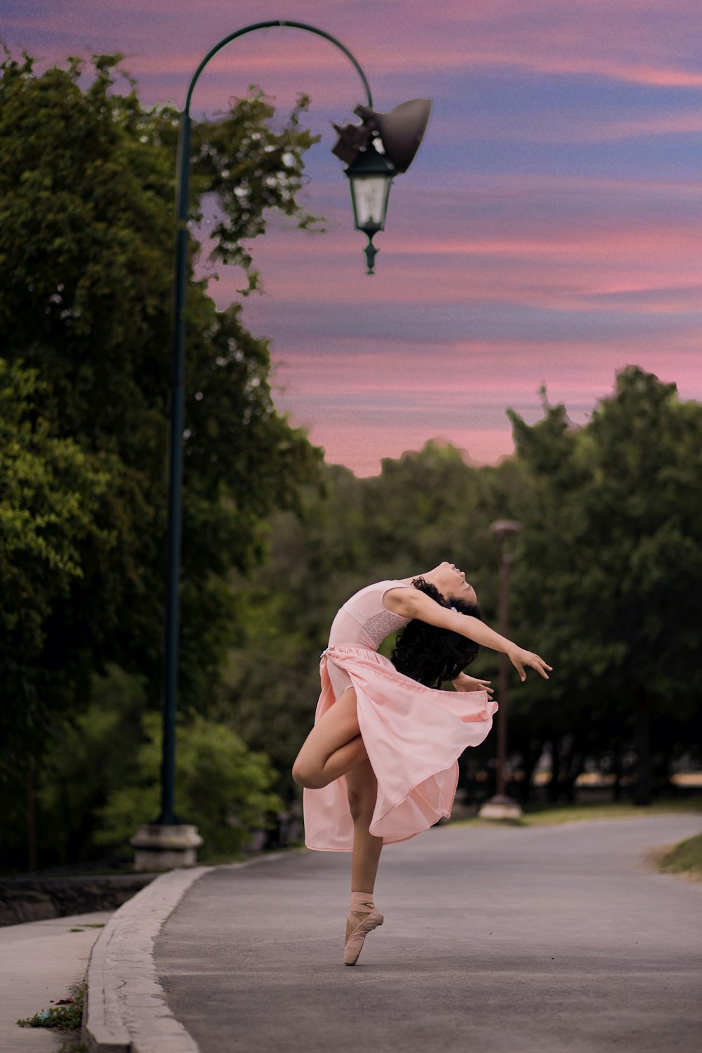 ballet dancer on road beside street lamp