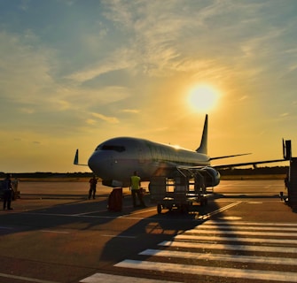 white airplane parked during daytime