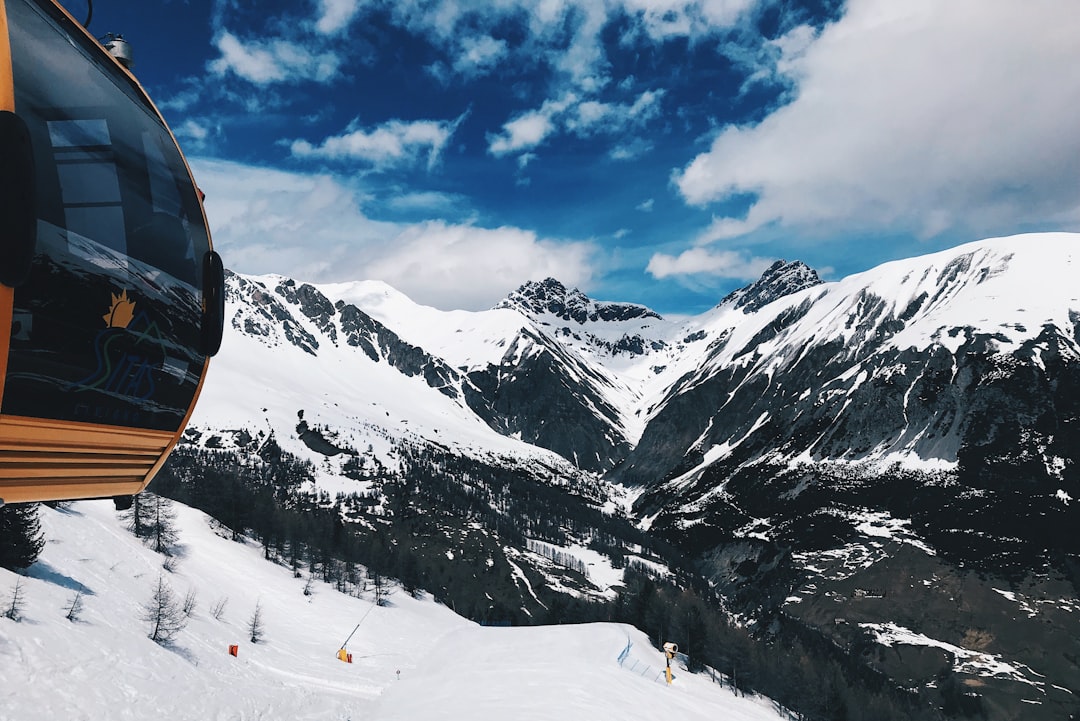 yellow cable car on snow mountain at daytime