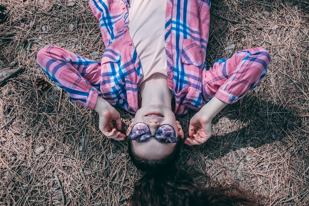 woman lying on ground with wilted grass