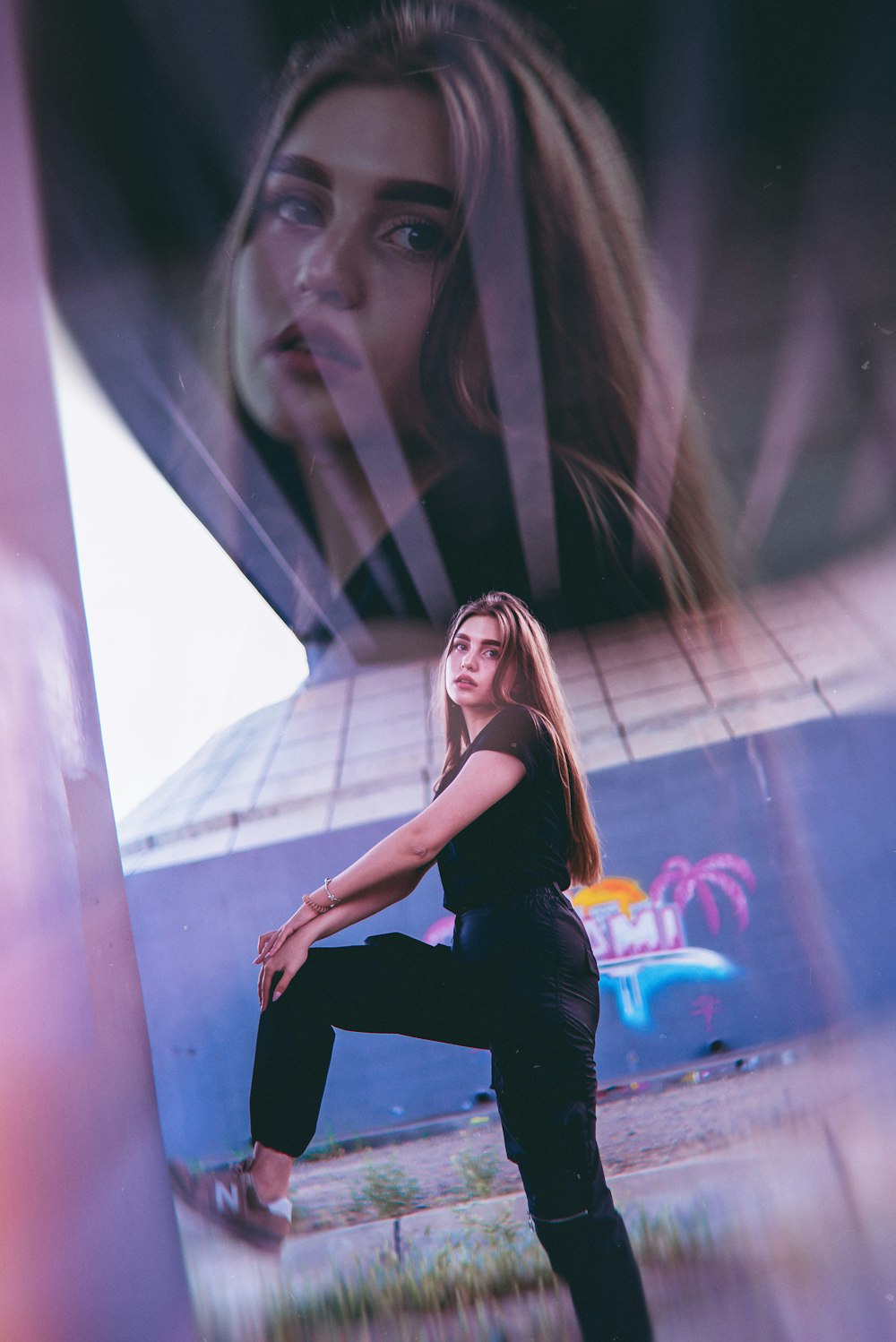 woman wearing black t-shirt standing under bridge during daytime