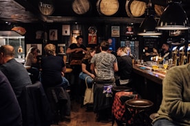 people sitting on bar chairs while drinking and talking