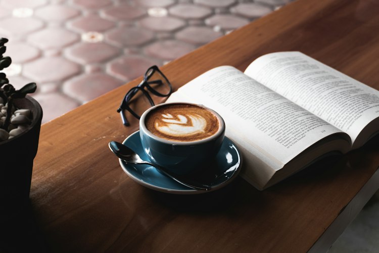 A person reading a book on a couch during a quiet evening