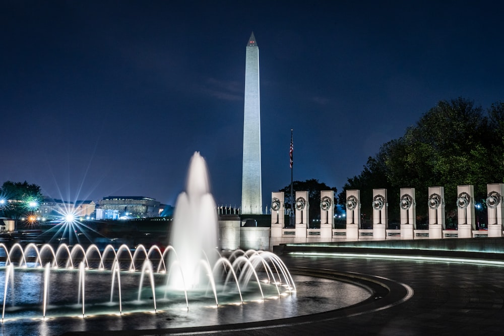 lighted tower building near water fountain in timelapse photo