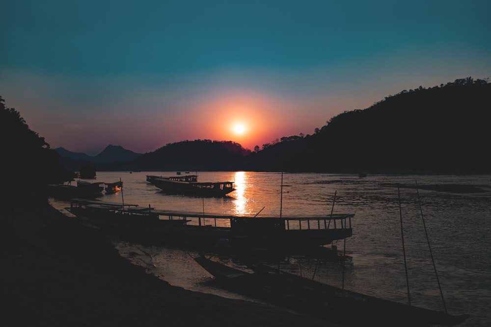 four boats on the river during sunset