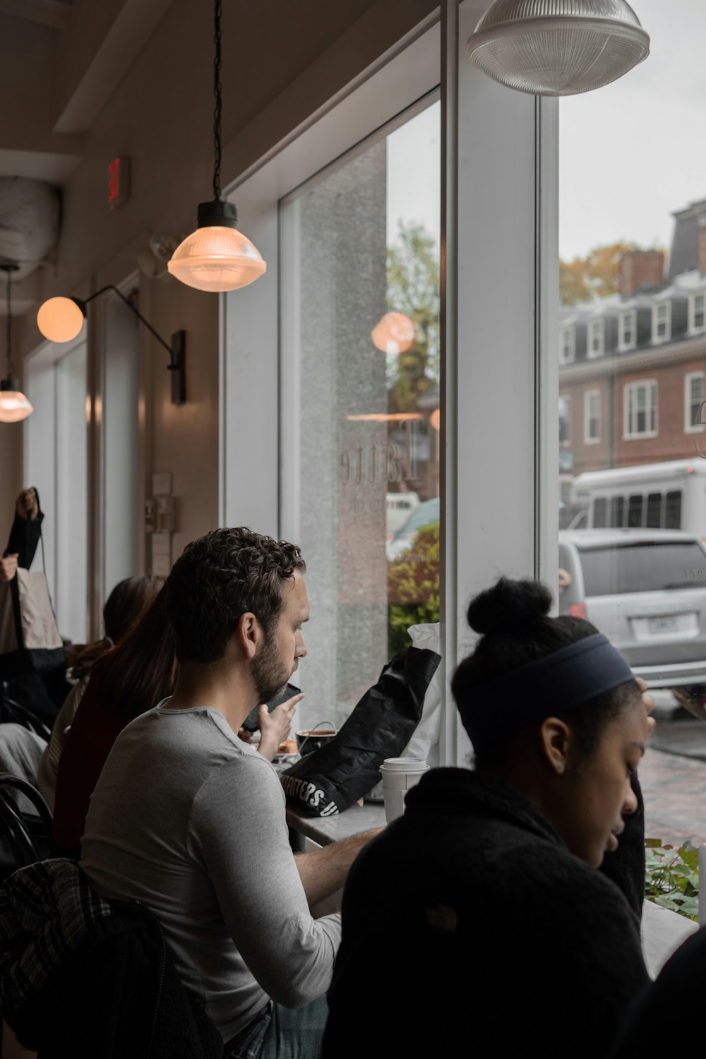 Die Leute sitzen am Tisch mit Blick auf die Fenster