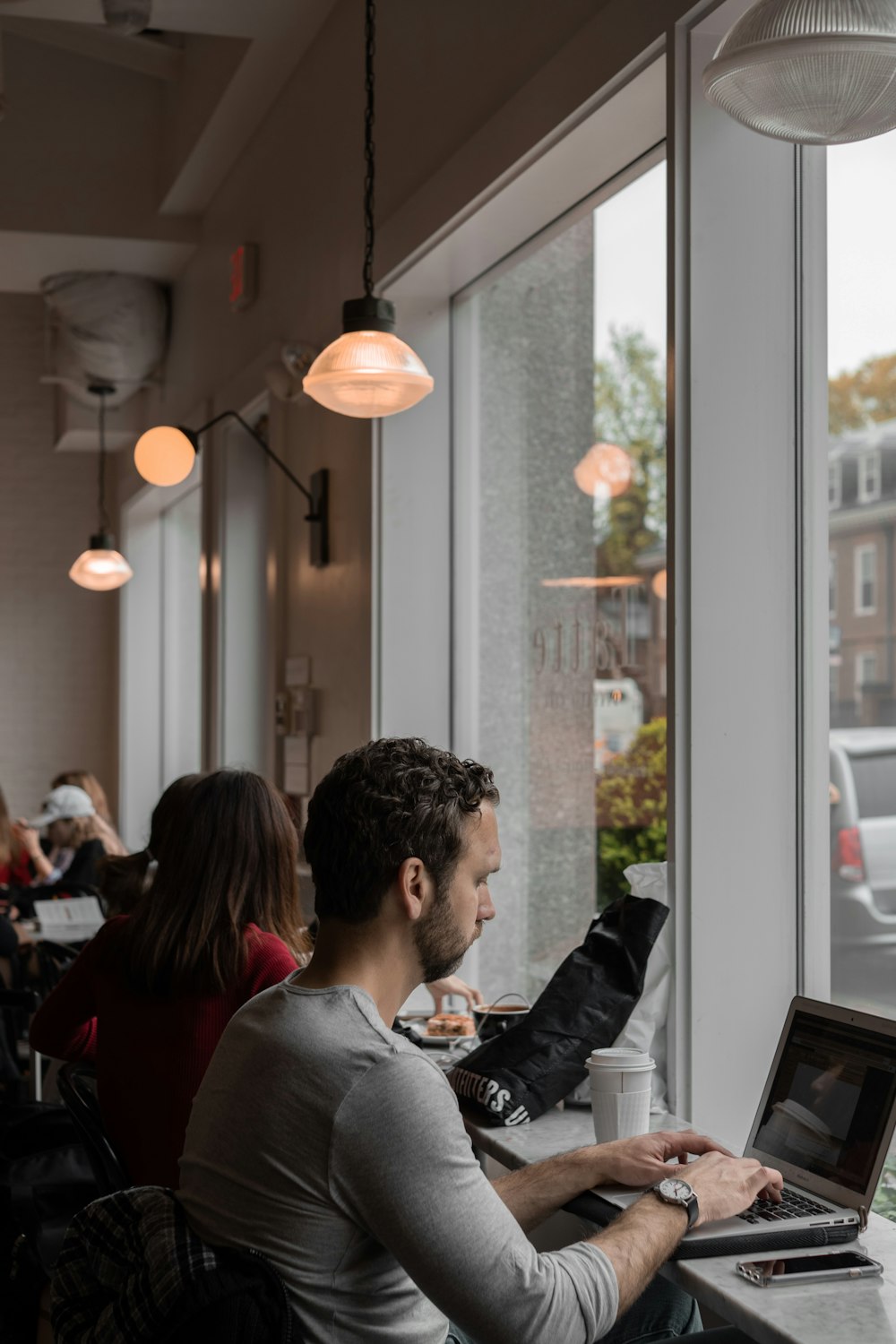 uomo che si siede e usa il computer portatile all'interno dell'edificio