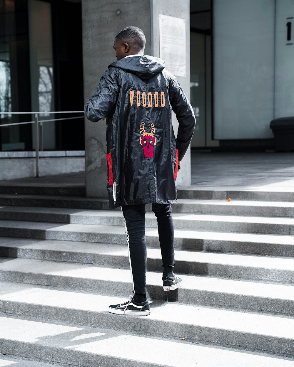 man in black jacket standing on stairs