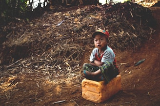 boy sitting on yellow container