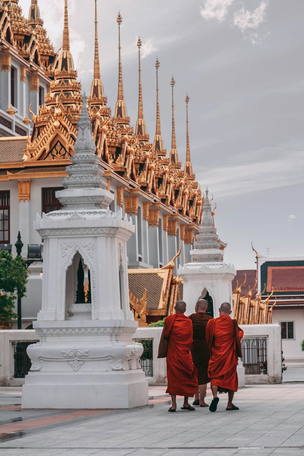 Drei Mönche gehen neben dem Tempel spazieren