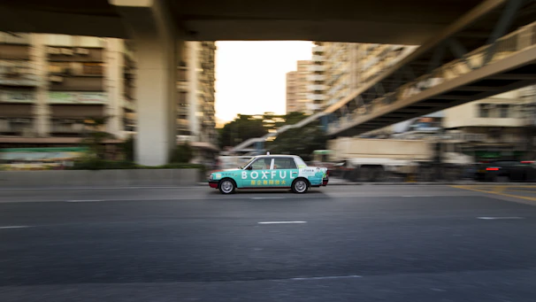 Close-up of a digital screen on a moving vehicle displaying colorful advertisements.