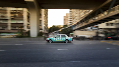 A sleek Uber car cruising through city streets with a vibrant VairoReklama ad on its door.