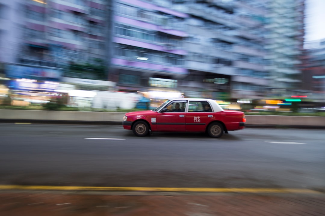 time lapse photography of red and white sedan passing by road