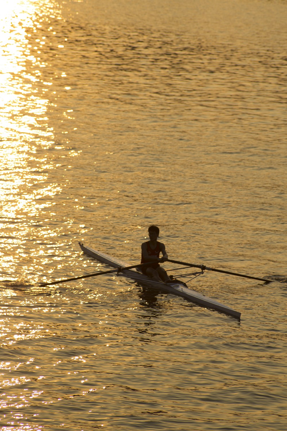 man riding on boat holding boat oar