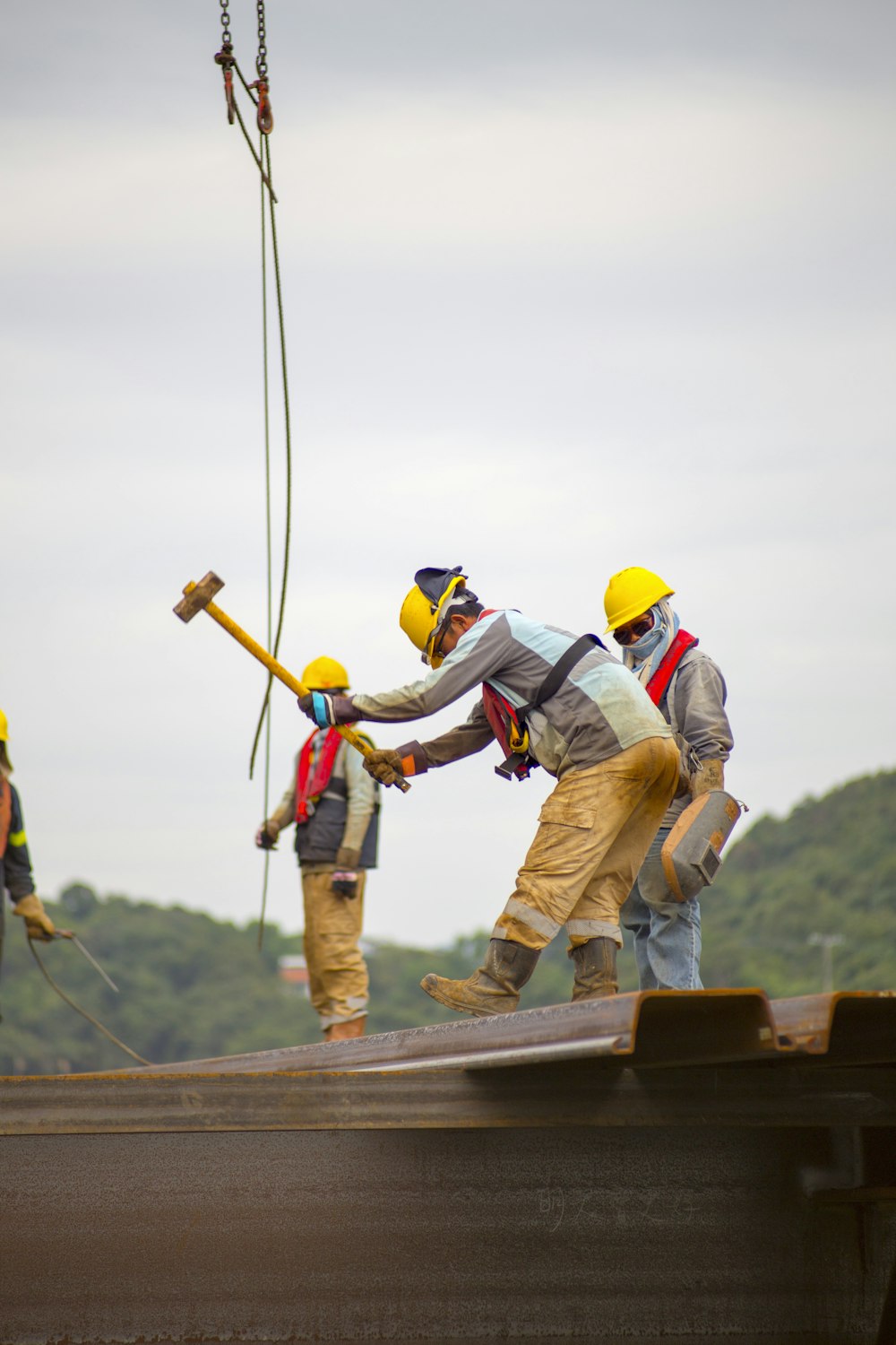 trabalhadores da construção civil segurando martelo