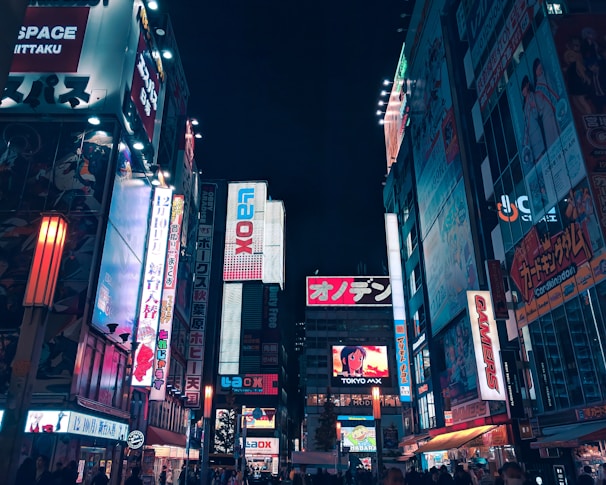 A vibrant street scene in Tokyo with colorful signs and bustling crowds at dusk.