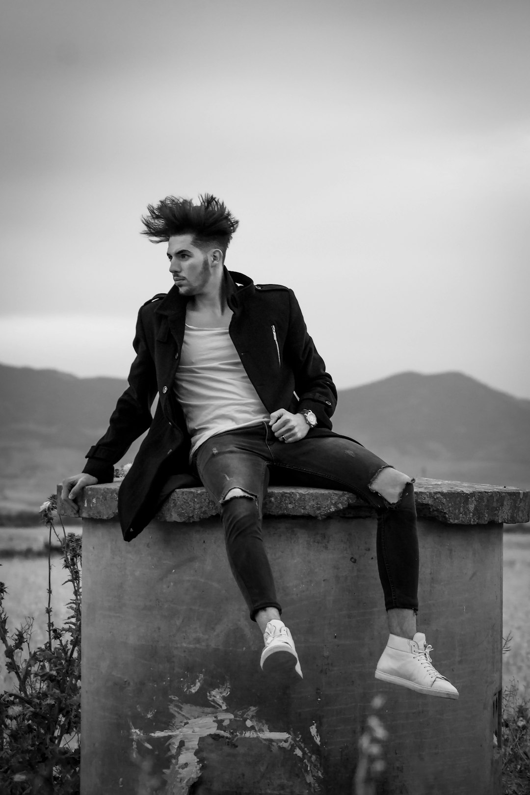 man in blazer sitting on concrete bench