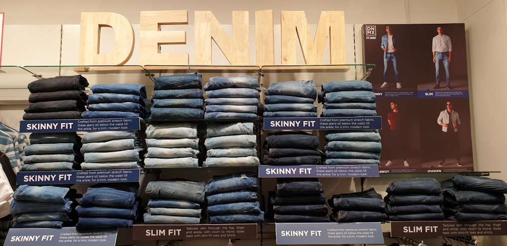A stylish display of various denim jeans in a modern store setting.