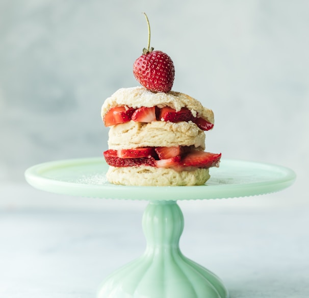 cake with strawberries on teal ceramic cake stand