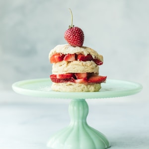 cake with strawberries on teal ceramic cake stand