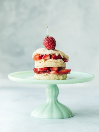 cake with strawberries on teal ceramic cake stand