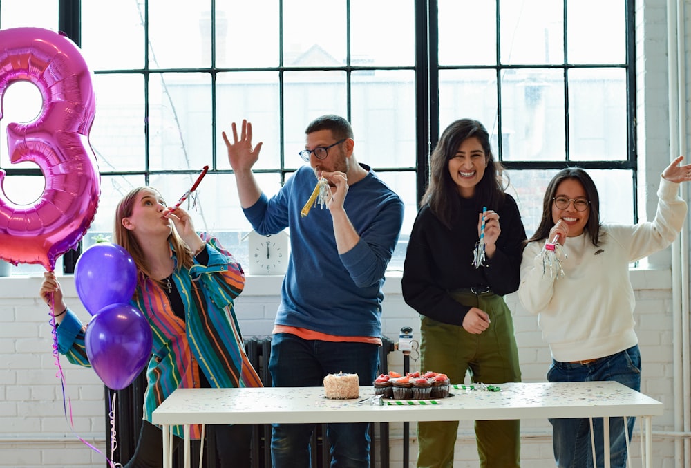 smiling people standing near table