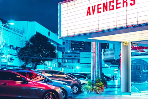vehicles parked beside Avengers signage