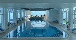 rectangular blue swimming pool inside white building