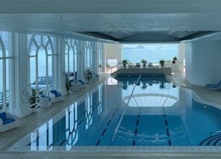 rectangular blue swimming pool inside white building