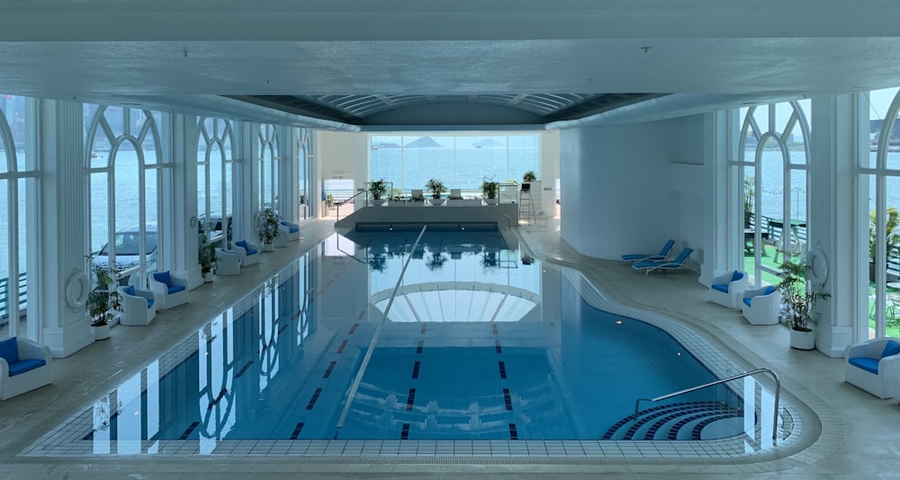 Piscina rectangular azul dentro de un edificio blanco