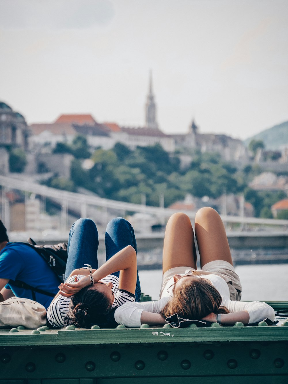 two women lying on green rooftop