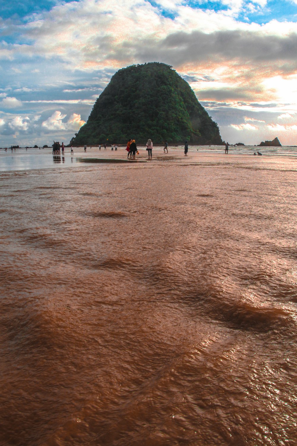 people standing near seashore under white and blue skies