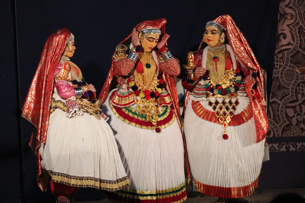a group of three women dressed in indian garb