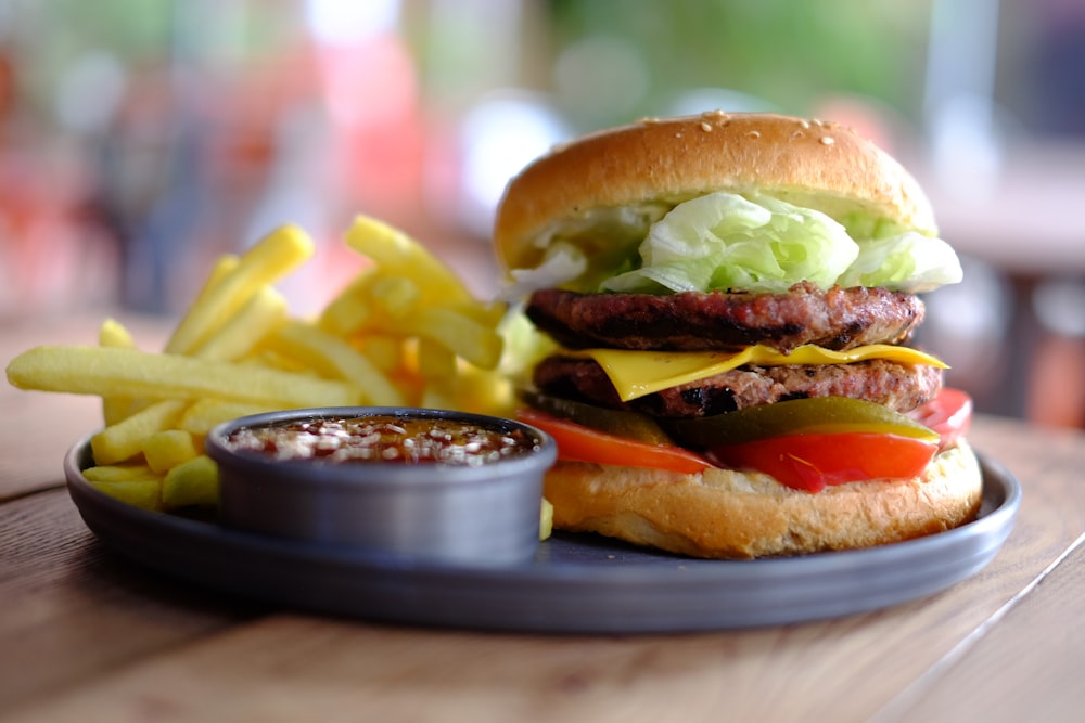 Hamburguesa y patatas fritas con salsa en bandeja