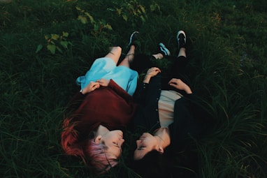 two women lying on grasses