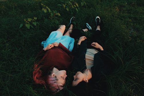 two women lying on grasses