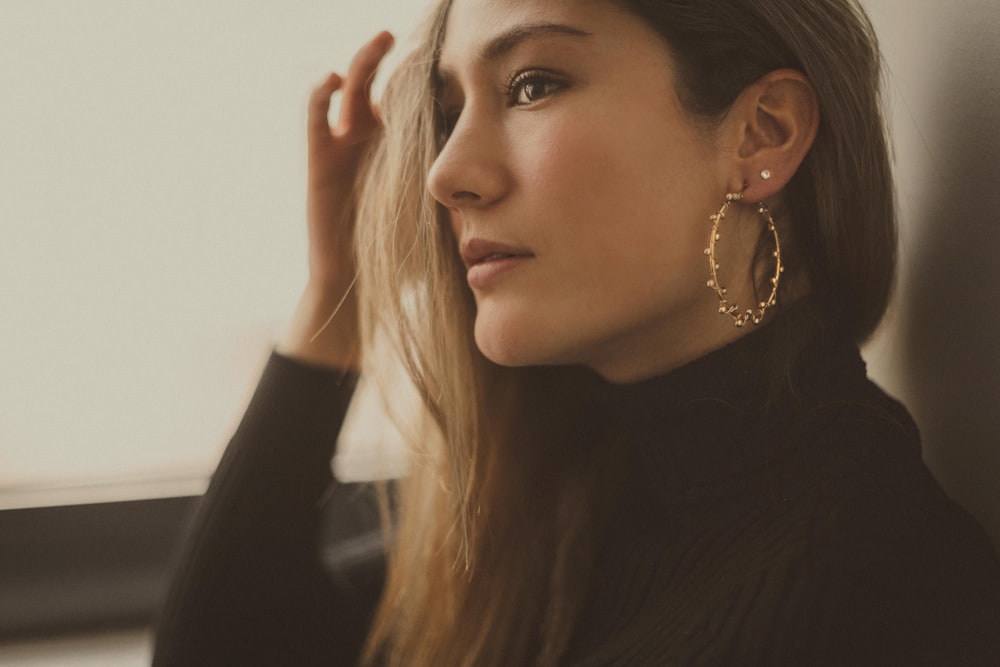 woman wearing black turtleneck long-sleeved top and hoop earring