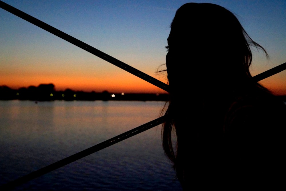 silhouette of woman beside sea