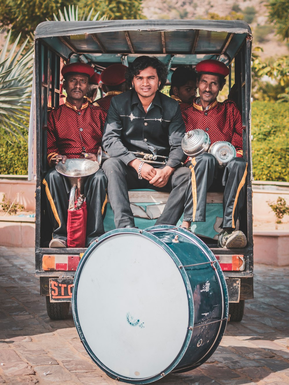 Pessoas em uniforme de banda andando em riquixá auto