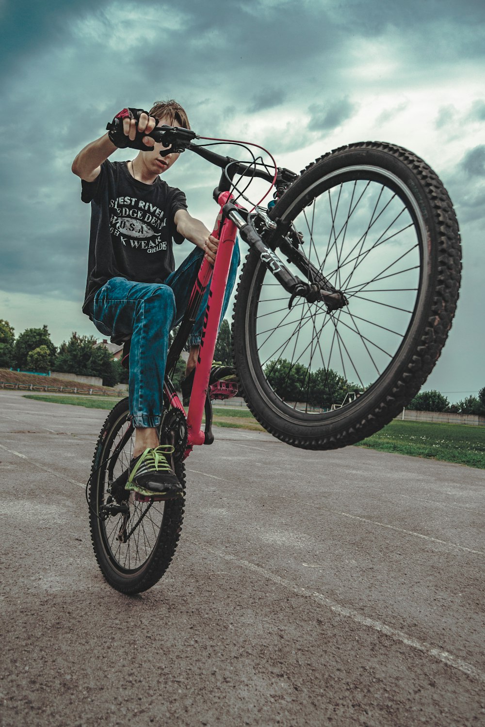 man riding bike and doing some stunts on pathway