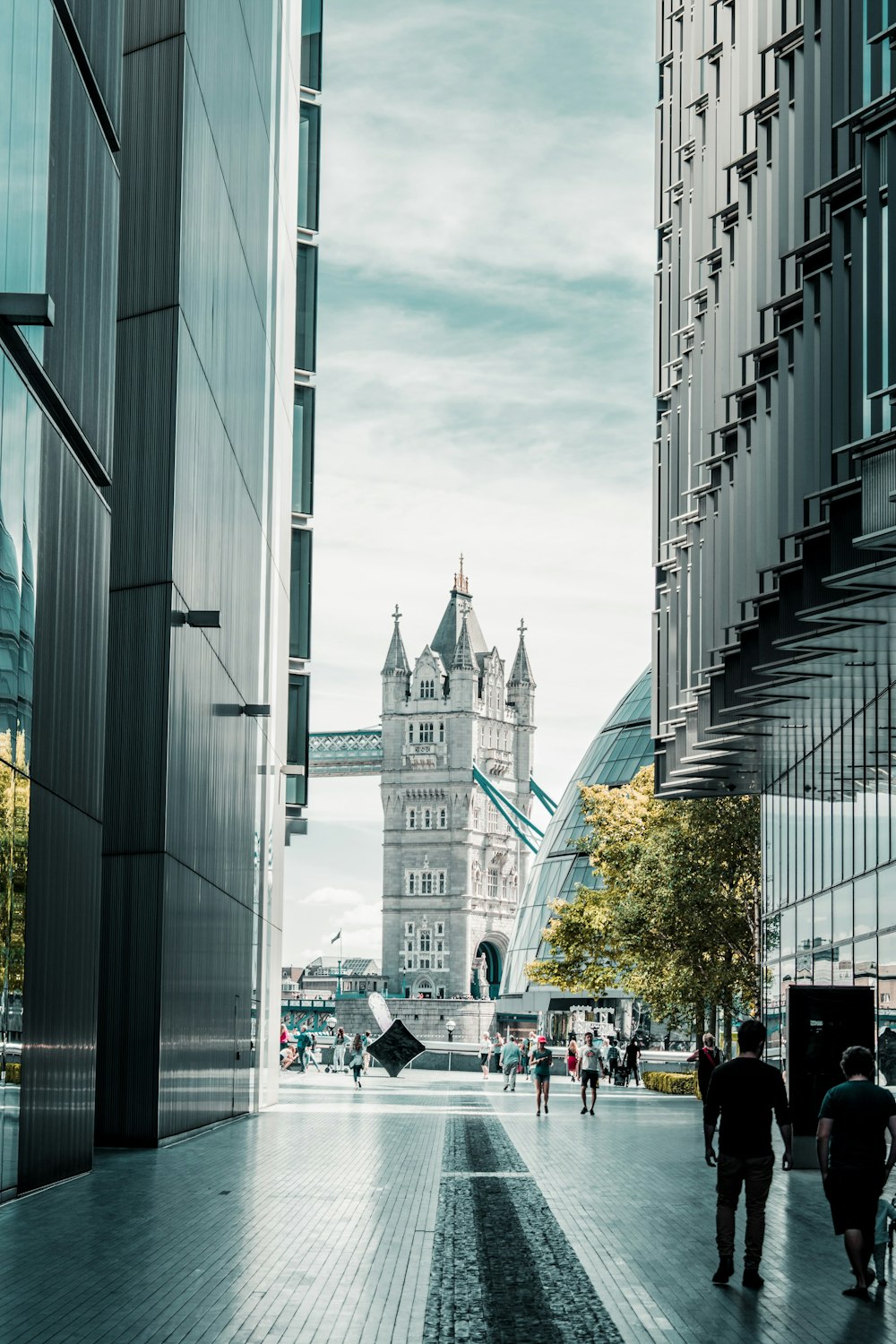 a group of people walking down a street next to tall buildings