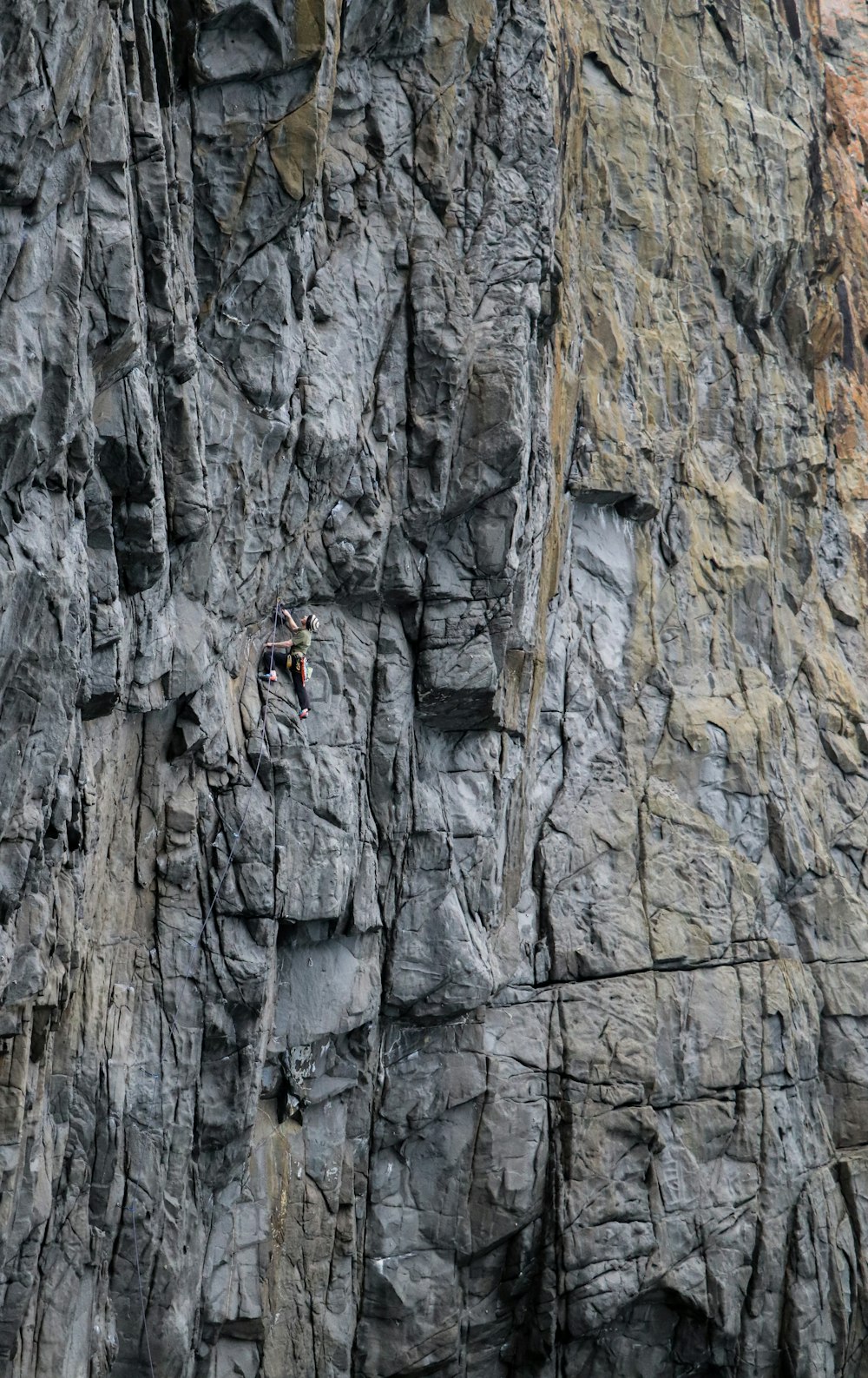 Un hombre trepando por la ladera de una montaña