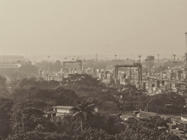 Industrial furniture and machinery being loaded into shipping containers at a port.