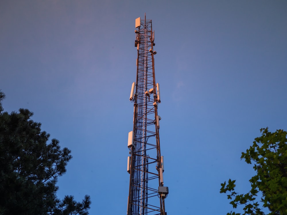 brown satellite tower near green trees