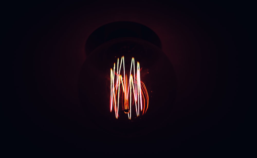 a red light bulb with a black background