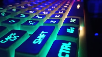 Close-up of a glowing neon blue and violet keyboard with gaming aesthetics.