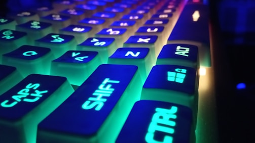 Close-up of a glowing neon blue and violet keyboard with gaming aesthetics.