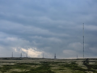 Wide shot of several communication towers spread across a rural landscape.