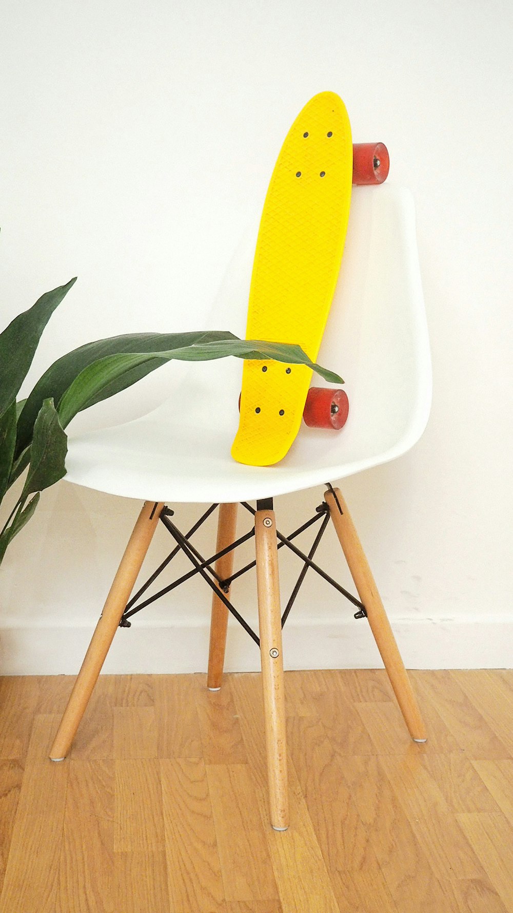 yellow penny board in white plastic chair